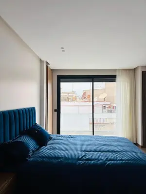 a bedroom with a blue bed and a large window at Premium Apt Casa City Center in Casablanca