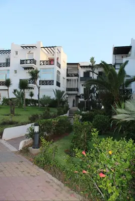 a group of buildings with trees and plants in front at K Playa Vibe Darbouazza in Dar Bouazza