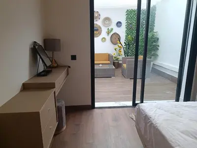 a bedroom with a bed and a sliding glass door at Sunny Studio Apartment with Courtyard in Casablanca