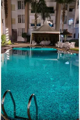 a large blue swimming pool with a gazebo at Cozy Room with Private Bathroom and Balcony in Casablanca