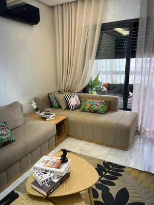 a living room with two couches and a table at Duplex Vue Piscine et Jardin Océan Park à Zenata City Eco in Aïn Harrouda