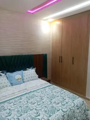 a bedroom with a large bed and a large cabinet at Perle Bouznika in Bouznika