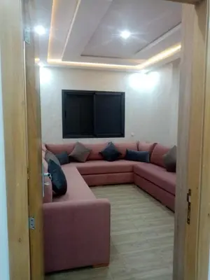 a living room with a pink couch and a flat screen tv at Perle Bouznika in Bouznika