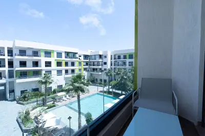 an apartment balcony with a view of a swimming pool at Elegant Comfort Pool Gym & Kids Club in Mohammedia