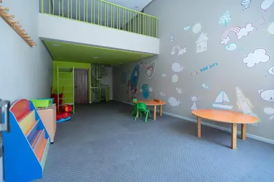 a room with two tables and a wall with stickers at Elegant Comfort Pool Gym & Kids Club in Mohammedia