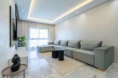 a living room with a couch and a table at Elegant Comfort Pool Gym & Kids Club in Mohammedia