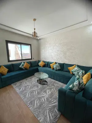 a living room with a blue couch and a table at Apparemment propre pour les familles in Casablanca