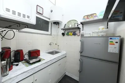 a small kitchen with a refrigerator and a sink at Hamouda Tabina in Rabat