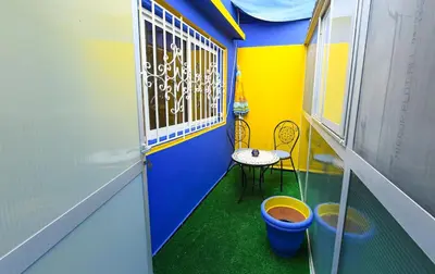 a small room with a balcony with a table and buckets at Hamouda Tabina in Rabat