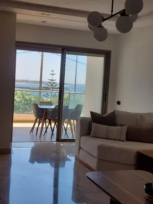 a living room with a couch and a table at Luxury apartment with sea view and 2 pools Sablettes in Mohammedia