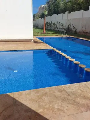 a swimming pool with blue water and concrete steps at Luxury apartment with sea view and 2 pools Sablettes in Mohammedia