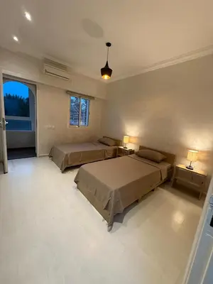 a large bedroom with two beds and two lamps at Pavilion à la corniche de mohammedia proche plage & centre-ville in Mohammedia