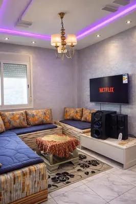 a living room with a couch and a tv at Casablanca APPARTEMENT 3 chambres in Casablanca