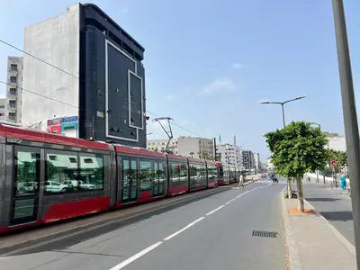 a red train on the side of a city street at Urban Comfort Casablanca - 3BR Family Apartment in Casablanca