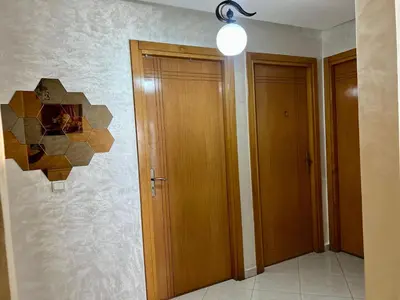 a hallway with two wooden doors and a light at Urban Comfort Casablanca - 3BR Family Apartment in Casablanca