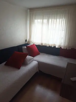 a room with two beds in front of a window at Apartment in Harhoura in El Harhoura