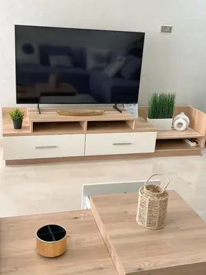 a living room with a large television and a table at Votre Cocon Moderne - Central & tout confort in Casablanca