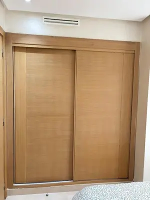 a closet with wooden doors in a bedroom at Votre Cocon Moderne - Central & tout confort in Casablanca