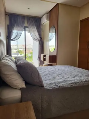 a bedroom with a bed and a large window at Lovely rental apartment with parking in premises, in Casablanca