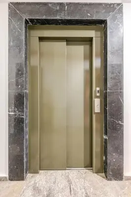 a elevator door in a building with a marble wall at Harcay CFC in Casablanca