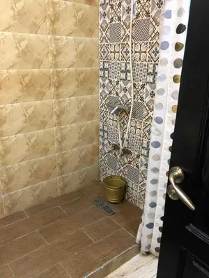 a bathroom with a shower with a tile wall at Appart face à la mer Garden Beach Sidi Rahal plage in Sidi Rahal