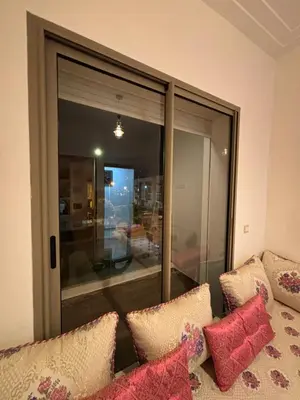 a room with a couch with pillows and a window at Appartement familiale in Tamaris