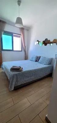 a bedroom with a bed with a blue comforter at Mansouria Appartement avec Piscine à proximité de la Plage in Mansouria