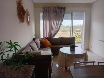 a living room with a couch and a table at residence ramo flores in Bir Jedíd Saint-Hubert