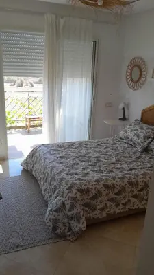a bedroom with a bed and a large window at residence ramo flores in Bir Jedíd Saint-Hubert