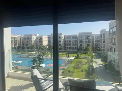 a view of a pool from a hotel room window at Beautiful appart with pool in Bouznika