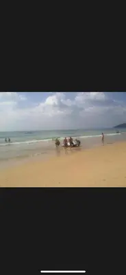 a group of people walking on the beach at Garden beach 2 in Sidi Rahal