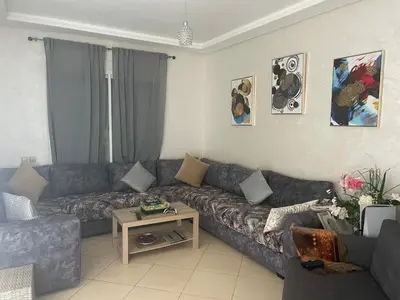 a living room with a couch and a table at Garden beach 2 in Sidi Rahal