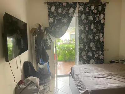 a bedroom with a bed and a sliding glass door at Garden beach 2 in Sidi Rahal