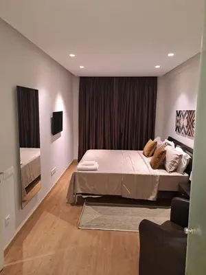 a bedroom with a large bed and a television at Holiday Appart in Casablanca