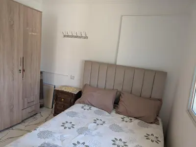 a bedroom with a bed and a wooden cabinet at Guesthouse Skhirat in Skhirat