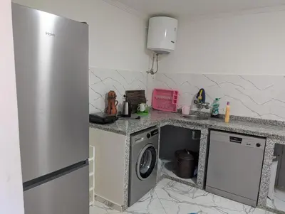 a kitchen with a refrigerator and a washing machine at Guesthouse Skhirat in Skhirat