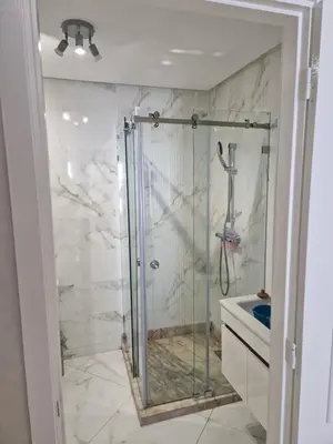 a shower with a glass door in a bathroom at Staycation Yakout in Mansouria