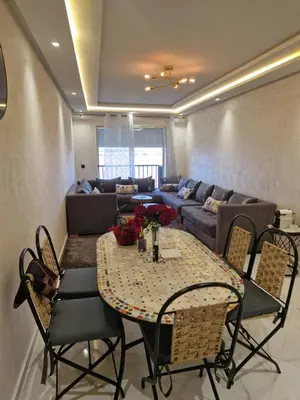 a living room with a table and a couch at Staycation Yakout in Mansouria