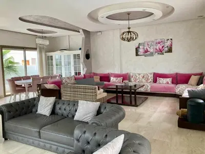 a living room with a couch and pink furniture at Belle et spacieuse villa avec piscine privée in Casablanca