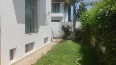 an apartment building with a grassy yard next to a building at Belle et spacieuse villa avec piscine privée in Casablanca
