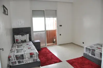 a bedroom with two beds and a red rug at Rental Apartment in Casablanca City Center in Casablanca