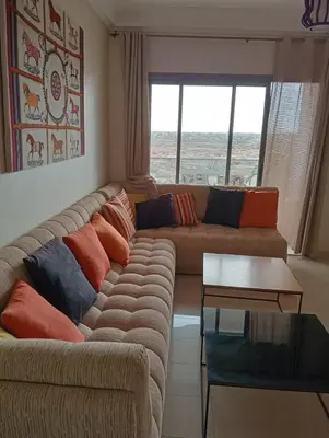 a living room with a couch and a table at 2 Bedrooms Blanca Beach in Sidi Rahal