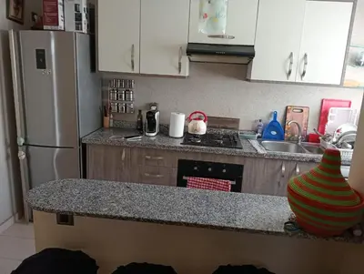 a kitchen with a refrigerator and a counter top with a stove at 2 Bedrooms Blanca Beach in Sidi Rahal
