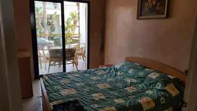 a bedroom with a bed with a green comforter at Appartement pour la CAN, Palm Beach - Mansouria in Mohammedia