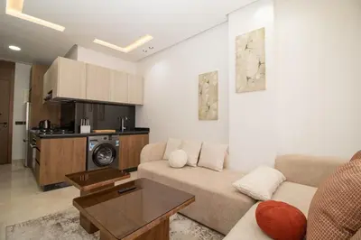 a living room with a couch and a kitchen at Modern Studio 5min CFC in Casablanca