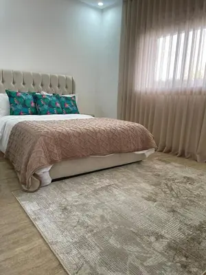 a bedroom with a bed with a large window at Appartement pieds sur mer in Sidi Rahal