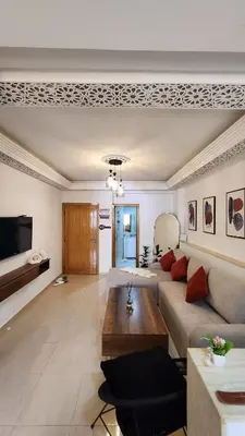 a living room with a couch and a table at Cosy and central condo with terace steps to shore in Rabat