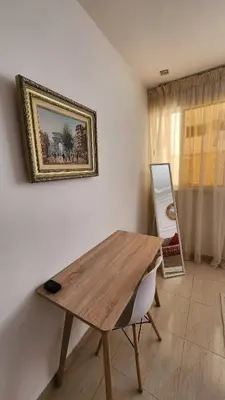 a wooden table in a room with a picture on the wall at Cosy and central condo with terace steps to shore in Rabat
