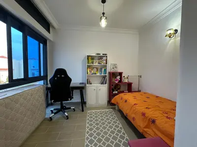 a bedroom with a bed and a desk and a chair at Maison ensoleillée à Skhirat, Piscine & Parking in Skhirat