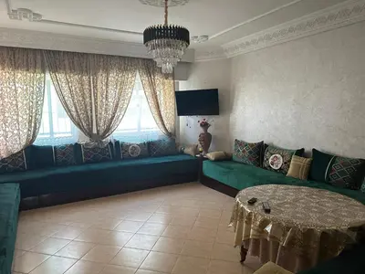 a living room with a couch and a table at Appartement A Darbouazza Tamaris 5min accès a la plage in Tamaris